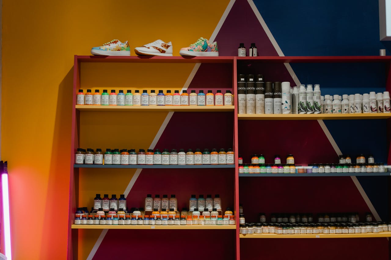 Colorful bottles and shoes arranged neatly on a vibrant geometric shelf display.